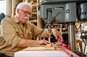 Man using drill press in workshop