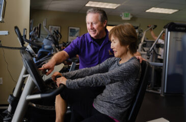 trainer helping woman on bike